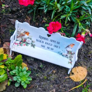 A personalised Christmas memorial bench featuring a winter design with white roses, holly and Robins.
